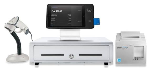 A complete Square retail counter: barcode scanner, iPad checkout on a stand, cash drawer, and receipt printer.